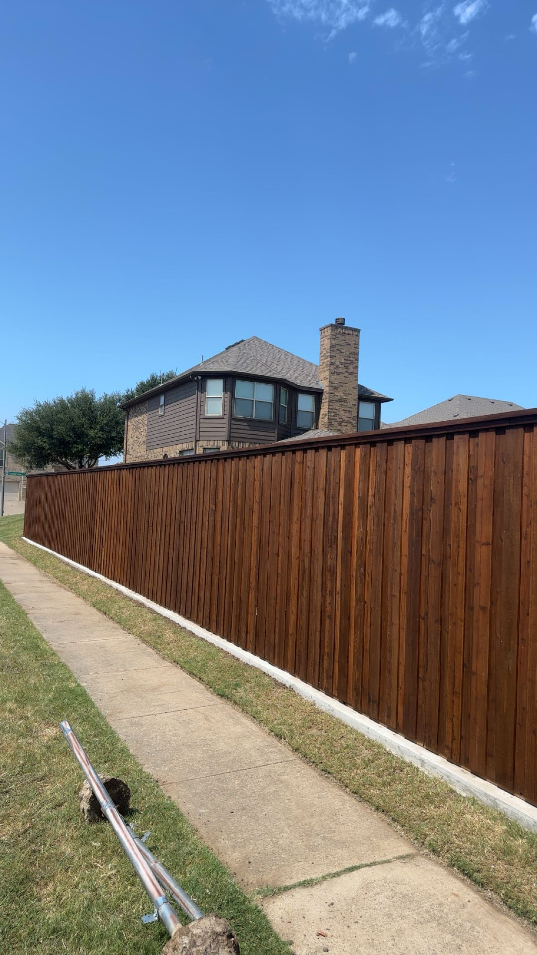 Long stained cedar cap and trim fence along a sidewalk in Manvel TX