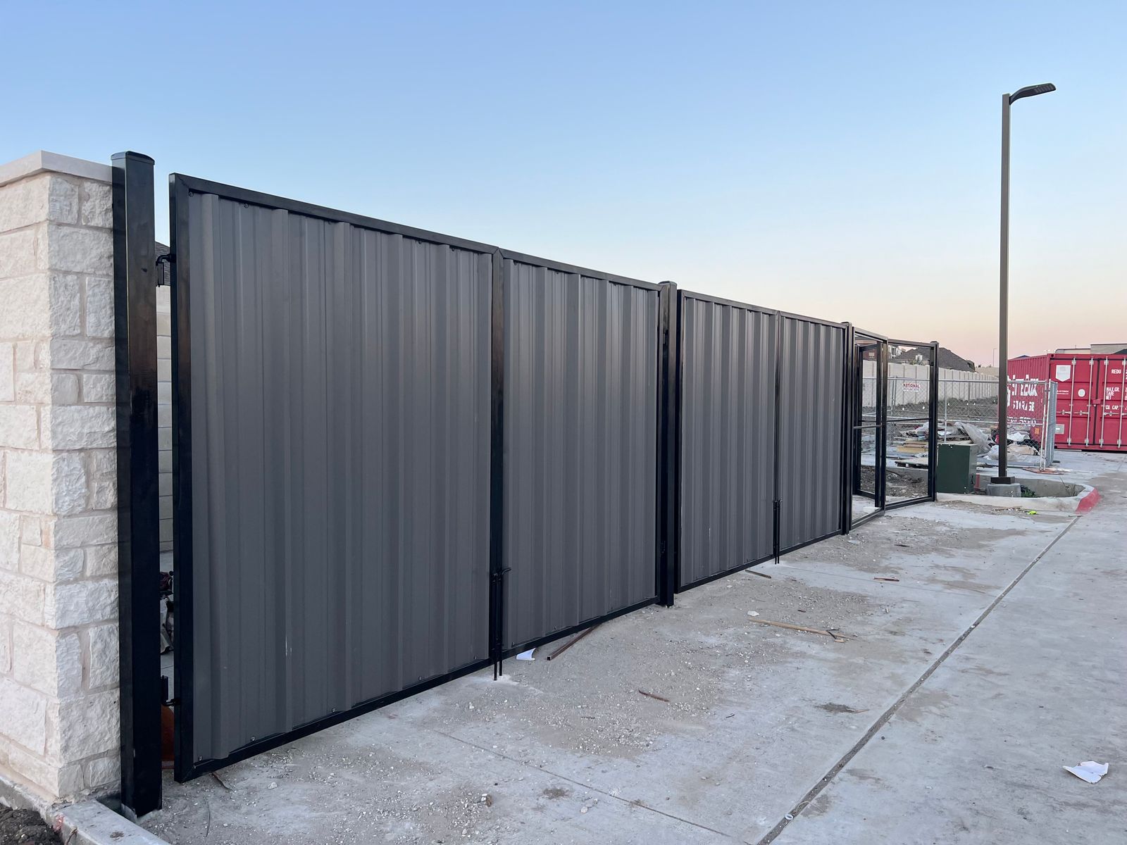 Commercial corrugated metal gate with stone columns in Pearland TX