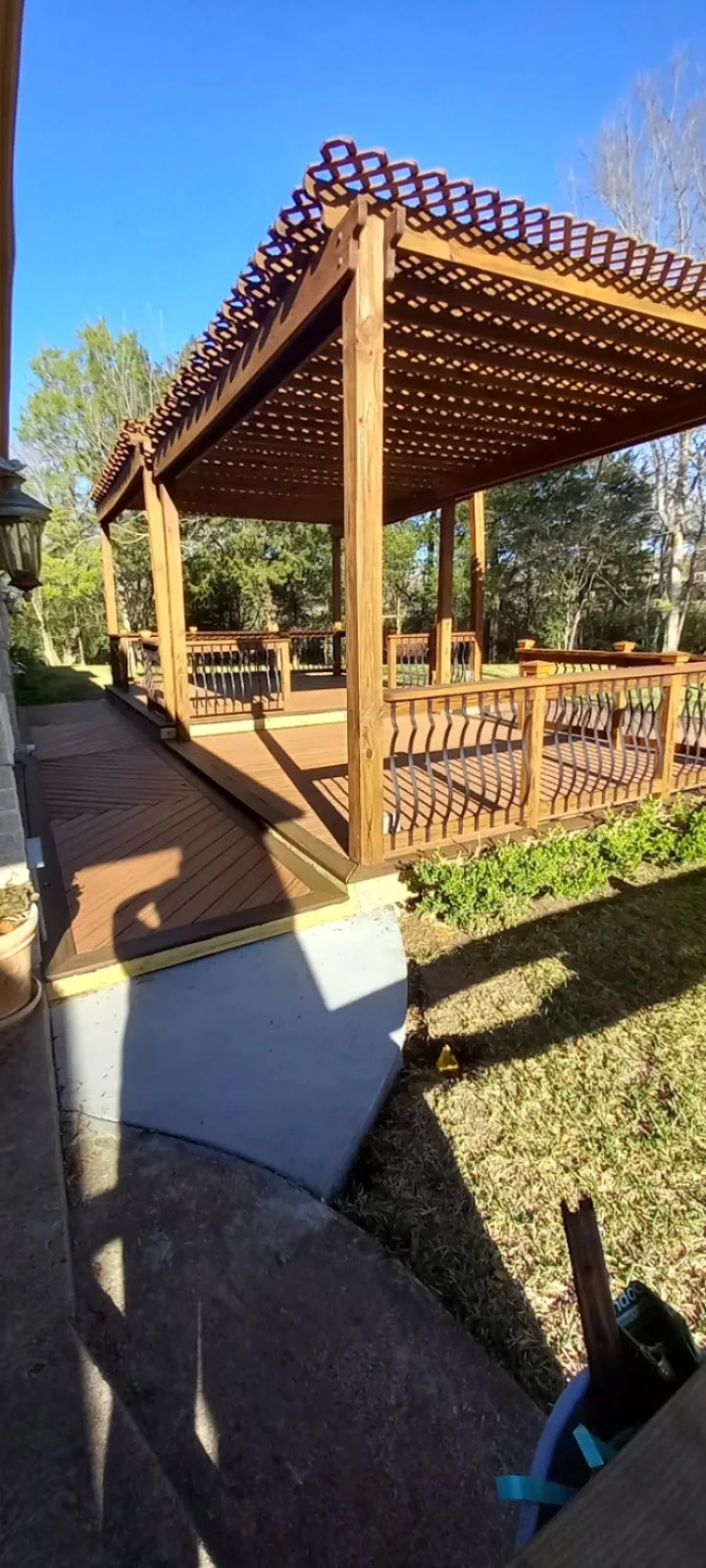 Cedar lattice-top pergola over a stained deck with ornamental railing in Pearland TX