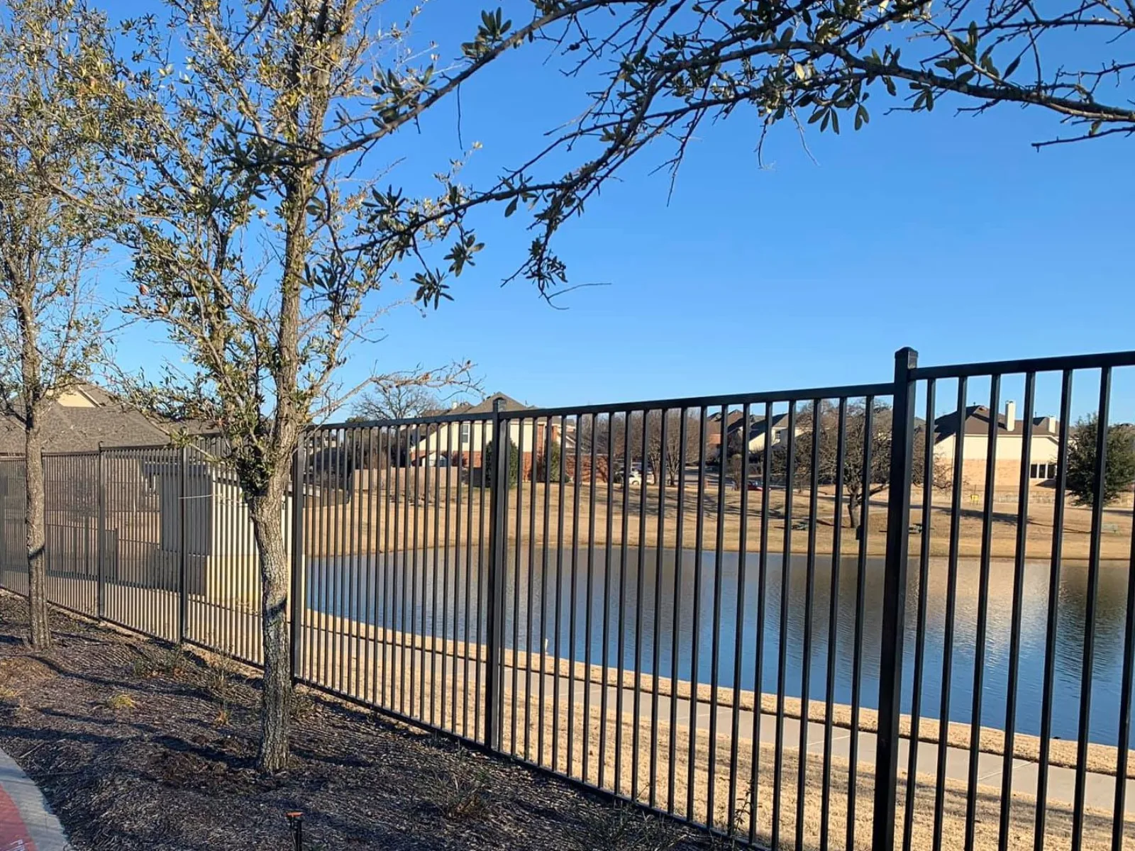 Black aluminum fence along a waterfront lot in Pearland TX