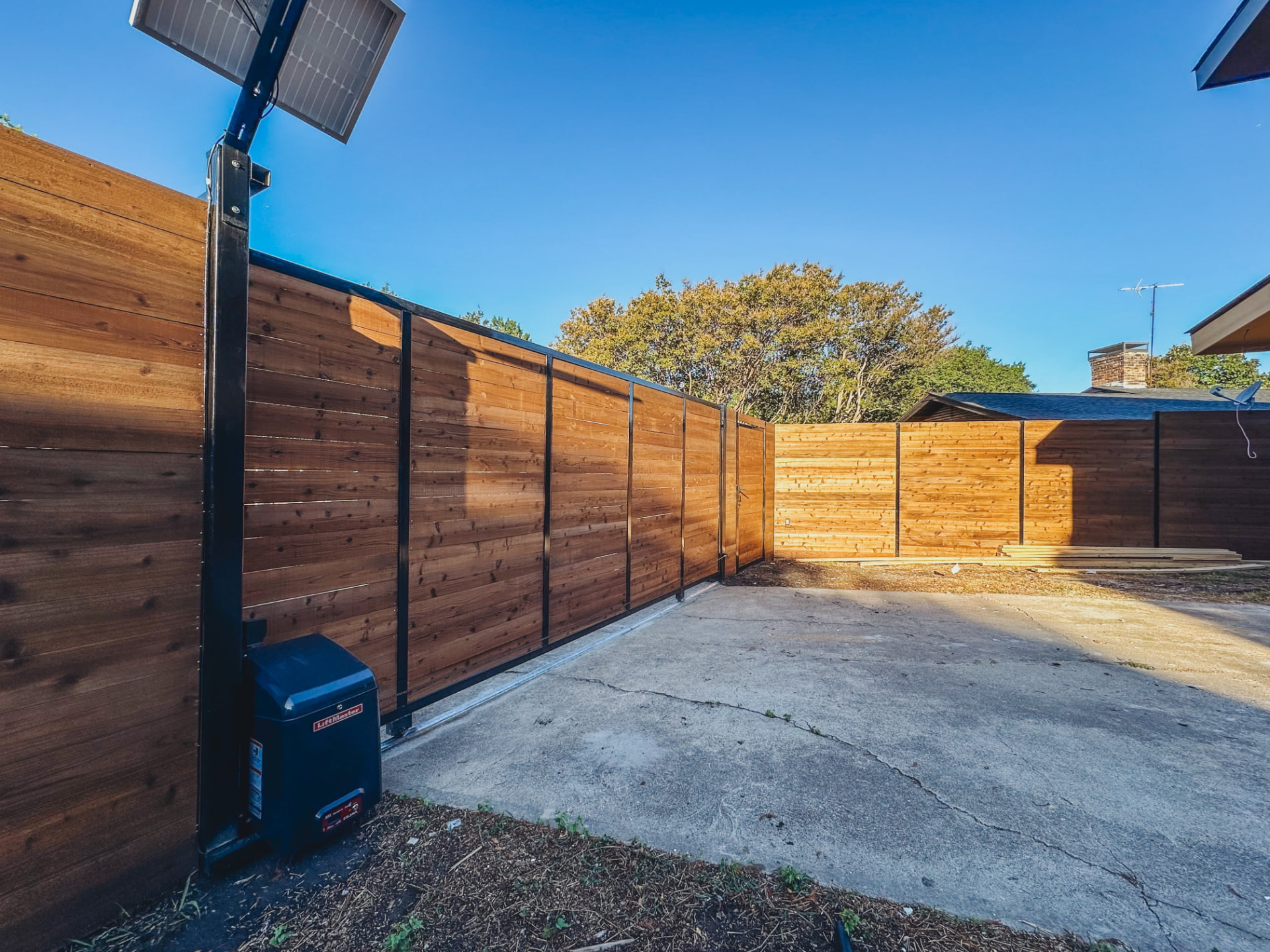 Horizontal cedar fence with black steel frame rolling gate in Pearland TX
